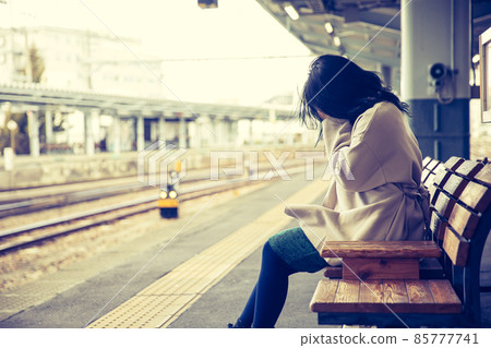 A woman crying at the platform of a station station 85777741