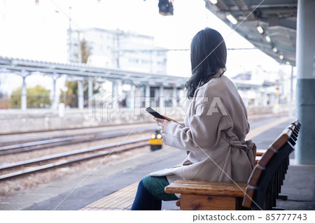 A woman crying at the platform of a station station A woman crying at the platform of a station station 85777743