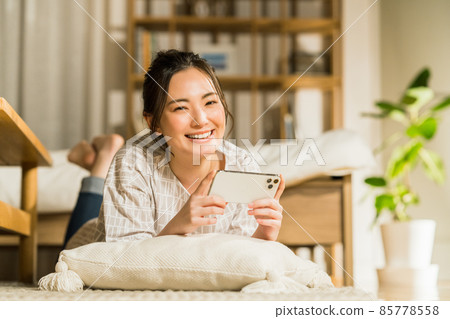 Young woman watching a video on her smartphone at night 85778558