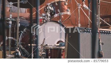 Concert, a man playing the drums. The concept of live, musical performance and virtuosity of playing percussion instruments Concert, a man playing the drums. The concept of live, musical performance and virtuosity of playing percussion instruments 85779053