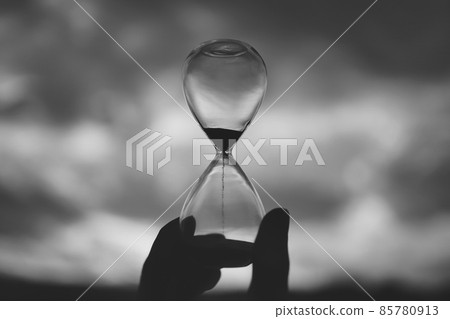 A person with a glass hourglass 85780913