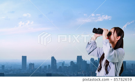 A woman looking at the city with binoculars 85782659