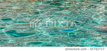 Emerald sea water in sunshine glow as surface background. Summer holidays concept Emerald sea water in sunshine glow as surface background. Summer holidays concept 85782717