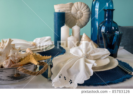 Marine style table setting - shells, starfish and blue glassware Marine style table setting - shells, starfish and blue glassware 85783126