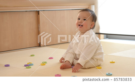 半笑著的嬰兒玩五顏六色的積木 85783833