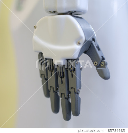 Metal robot hand on a gray background, close-up Metal robot hand on a gray background, close-up 85784685