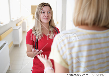 A doctor in listens to a woman in the hospital corridor 85784928