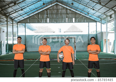 four futsal players standing in a row carrying the ball 85785485
