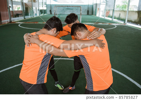 group of futsal players gather in a circle before game 85785827