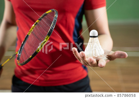 Badminton player in red shirt holding racket and shuttlecock 85786058