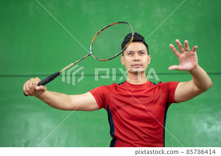 Asian male badminton player ready to receive the shuttlecock 85786414