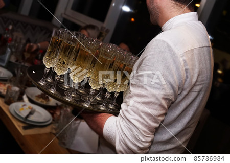 A waiter holding glasses with champagne served on a tablet 85786984