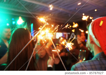 Friends celebrating Christmas or New Year eve party with Bengal lights 85787027