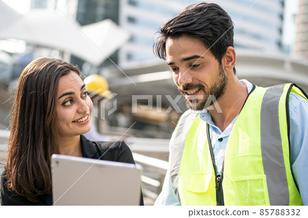 Engineers and executives are discussing plans in the construction site. 85788332