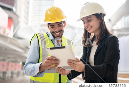 Engineers and executives are discussing plans in the construction site. 85788333