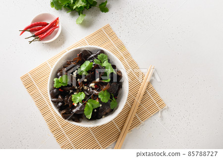 Salad of chinese pickled tree black muer mushrooms with chilli pepper and coriander leaves in bowl. Salad of chinese pickled tree black muer mushrooms with chilli pepper and coriander leaves in bowl. 85788727