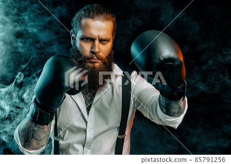 bearded man in white shirt wears boxing gloves and ready to fight. Man self defense. Studio shot bearded man in white shirt wears boxing gloves and ready to fight. Man self defense. Studio shot 85791256