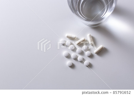 Medicine and water on white background 85791652