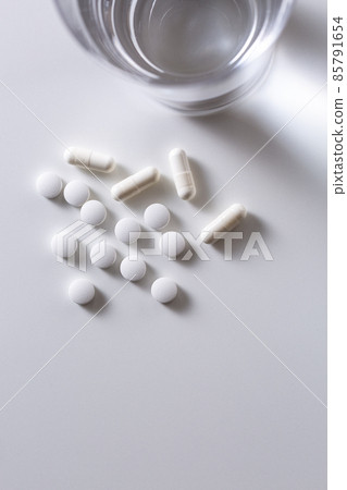 Medicine and water on white background Medicine and water on white background 85791654