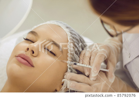 Woman receiving safe injection of youth. Beautiful lady getting corrective dermal aesthetic improvement. Skincare specialist doing restylane, silicone or PRP treatment for perfect rejuvenation 85792076