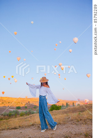 Happy woman during sunrise watching hot air balloons in Cappadocia, Turkey 85792289