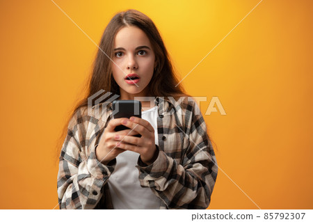 Portrait of a smiling young girl using smartphone 85792307