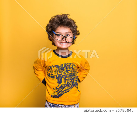 Funny surprised little child boy in glasses looking in camera isolated on yellow background. Kindergarden kid smiling. Education for smart children Funny surprised little child boy in glasses looking in camera isolated on yellow background. Kindergarden kid smiling. Education for smart children 85793043