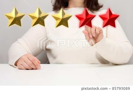 Customer experience feedback concept. Five red stars, the best rating of excellent services with a female hand to meet. White table 85793089