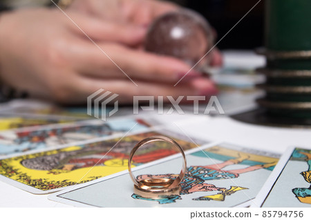 Wedding rings are on Tarot cards. The Gypsy lays out Tarot cards and guesses for the future. Magic sessions with talking Tarot cards with heart and wedding rings Wedding rings are on Tarot cards. The Gypsy lays out Tarot cards and guesses for the future. Magic sessions with talking Tarot cards with heart and wedding rings 85794756