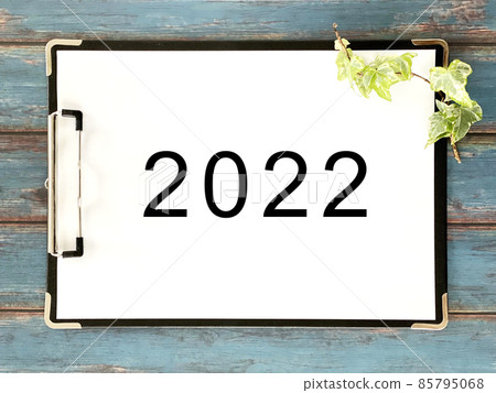 White paper with 2022 characters sandwiched between clipboards 85795068