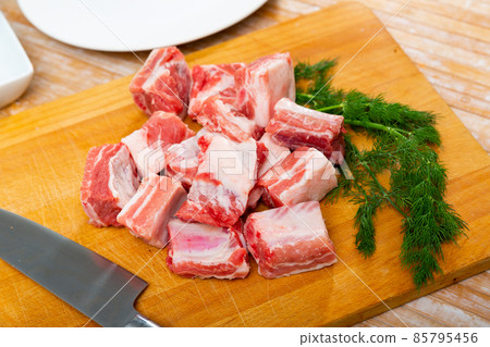 Unprepared pork ribs chopped on table and ready-to-cook 85795456