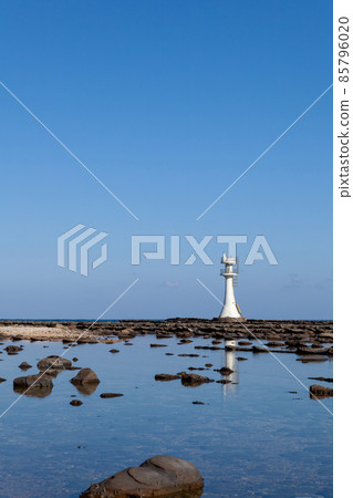 A white lighthouse that guides the god of the sea enshrined in Aoshima Shrine of Kaizumigu on the devil's washboard that was raised in the blue sky of Hyuga-nada, Miyazaki. 85796020