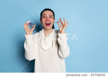 Shocked young Caucasian girl feeling sick isolated over blue background. Flu, cold, allergy Shocked young Caucasian girl feeling sick isolated over blue background. Flu, cold, allergy 85796692