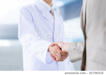一個穿白大褂的男人和一個女商人握手 85796926
