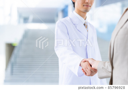一個穿白大褂的男人和一個女商人握手 85796928