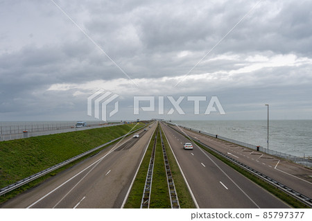 The Afsluitdijk is a major dam and causeway in the Netherlands. It is a fundamental part of the larger Zuiderzee Works, damming off salt water of the North Sea, and turning it into a fresh water lake 85797377