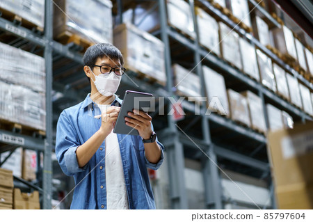 New Normal Asian men, staff, product wearing face mask. counting Warehouse Control Manager Standing, counting and inspecting products in the warehouse 85797604