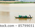 Fisherman operating a boat on the Mekong River in Cambodia 85799031