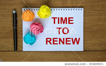 White note with inscription 'time to renew' on beautiful wooden table, colored paper, pen, cap. Business concept. 85800931