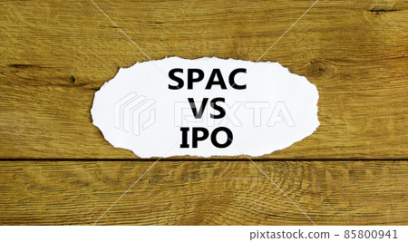 SPAC vs IPO symbol. Words 'SPAC, special purpose acquisition company vs IPO, initial public offering' on white paper. Beautiful wooden background. Business and SPAC vs IPO concept. 85800941