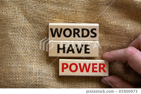 Wooden blocks form the words 'words have power' on canvas background. Male hand. Business concept. Wooden blocks form the words 'words have power' on canvas background. Male hand. Business concept. 85800973