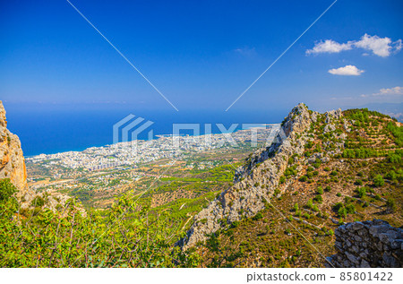 Aerial view of Kyrenia Girne mountain range and valley in front of Mediterranean sea, green trees on rock foreground 85801422