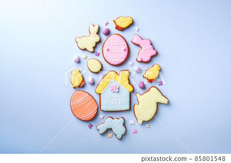 Easter greeting card with colorful rabbits, eggs, chickens gingerbread cookies on blue background with copy space. Mock up. Banner. Top view. 85801548