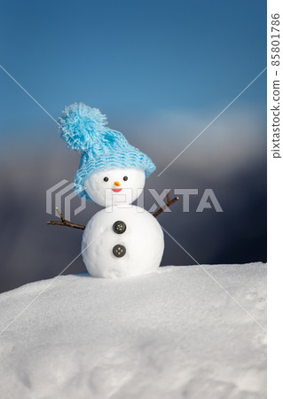 Snowy mountain, blue sky and snowman with a light blue hat 85801786