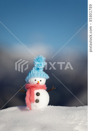 Snowy mountain, blue sky and snowman with a light blue hat 85801789