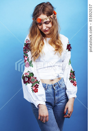 young pretty blond girl posing on blue background, fashion style hippie boho flowers on head young pretty blond girl posing on blue background, fashion style hippie boho flowers on head 85802037