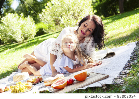young pretty pregnant brunette woman having fun with her daughter on picnic on green grass in park, lifestyle people concept young pretty pregnant brunette woman having fun with her daughter on picnic on green grass in park, lifestyle people concept 85802054