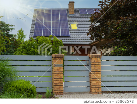 Beautiful modern house with solar panels. Clear sky, sun and lots of greenery Beautiful modern house with solar panels. Clear sky, sun and lots of greenery 85802578