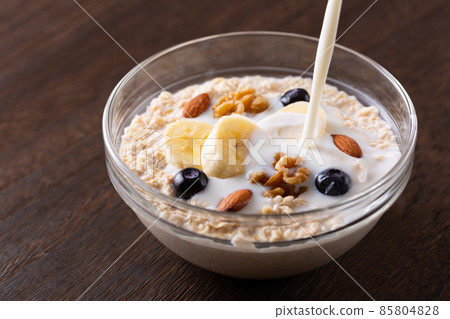 Pour milk into oatmeal 85804828