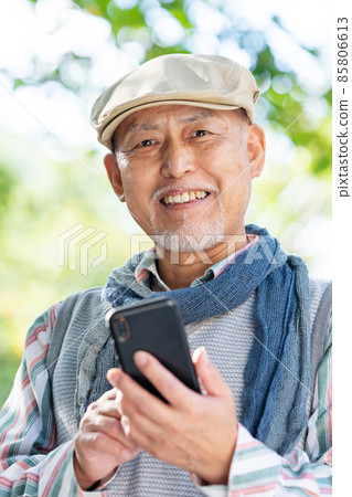 Senior male smartphone outdoor green Senior male smartphone outdoor green 85806613